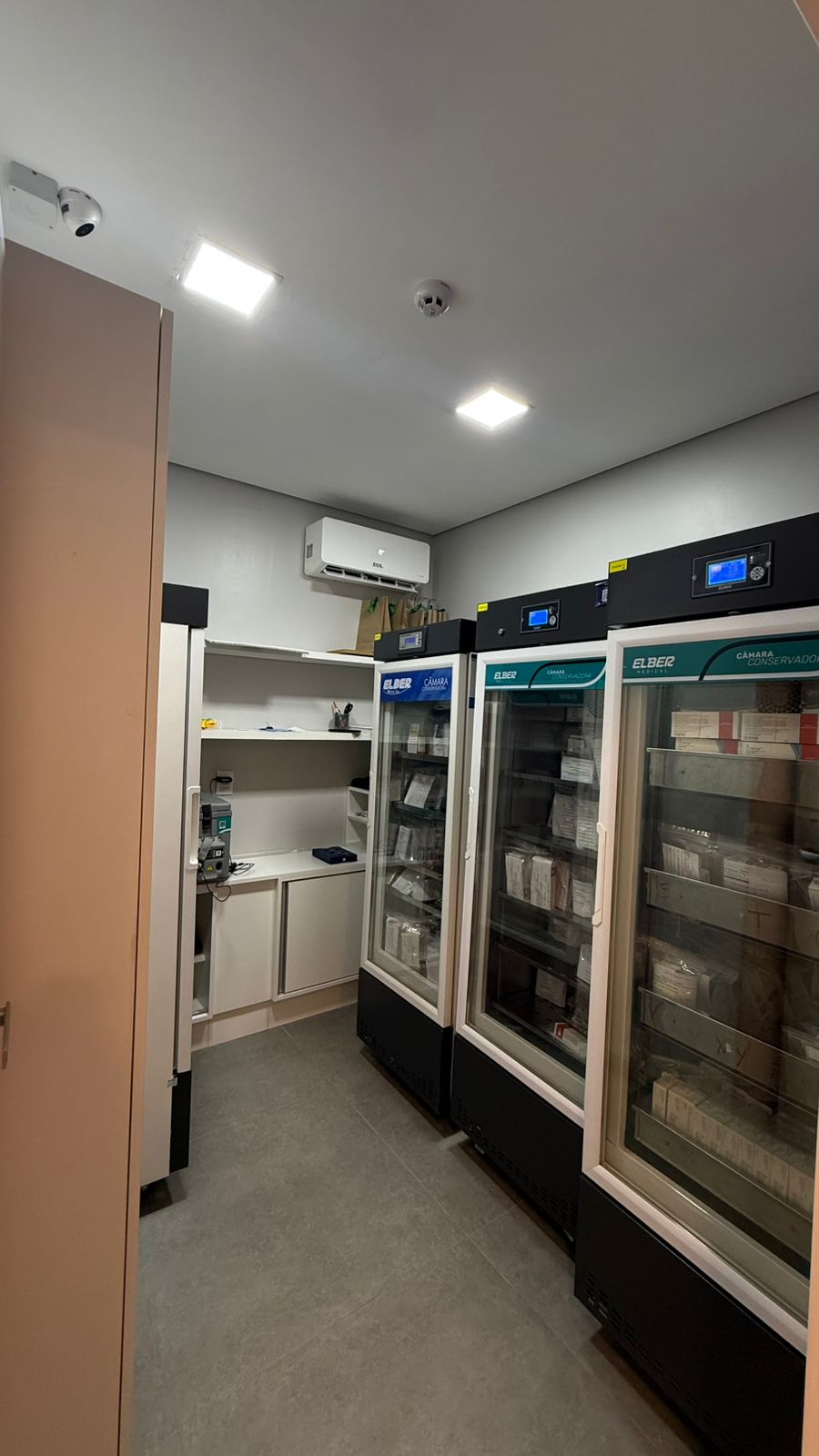 Sala de conservação de vacinas da NH Vacinas, com câmaras refrigeradas verticais e painéis digitais de temperatura